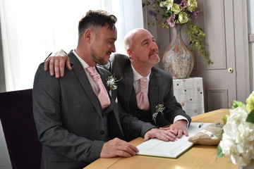 Portrait of a loving gay male couple on their wedding day.
