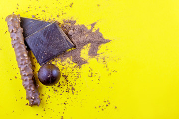 Top view of a variation of chocolate on a yellow background