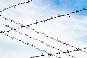 Fototapeta na wymiar barbed wire on background of blue sky