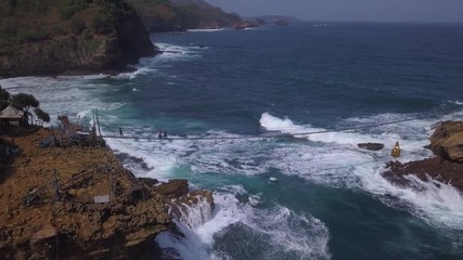 Aerial: Drone flying near suspension bridge , attraction on Timang beach, Java island, Indonesia
