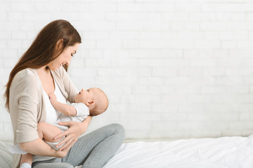 Fototapeta premium Young mother enjoying to spend time with her newborn son