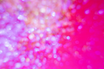 Christmas festive blurred background - colorful sparkles close-up in a trendy neon pink light. Macro photo. Abstract bright image. The concept of holidays, parties.