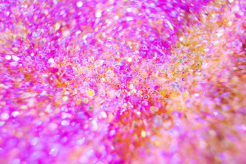 Christmas festive disco background - colorful sparkles close-up in a trendy neon light. Macro photo. Abstract bright image. The concept of holidays, parties.