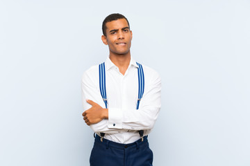 Young handsome brunette man with suspenders over isolated background having doubts and with confuse...