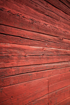 Verwitterte rote Blockhaus Fassade. Weathered red log house facade.