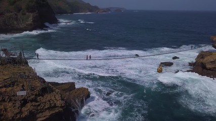 Aerial: Drone flying near suspension bridge , attraction on Timang beach, Java island, Indonesia
