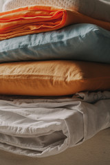 Stack of multi-colored bedding and pillows