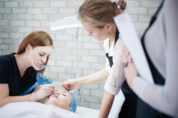 Permanent makeup courses. Female beautician using tattoo machine for eyebrow microblading.