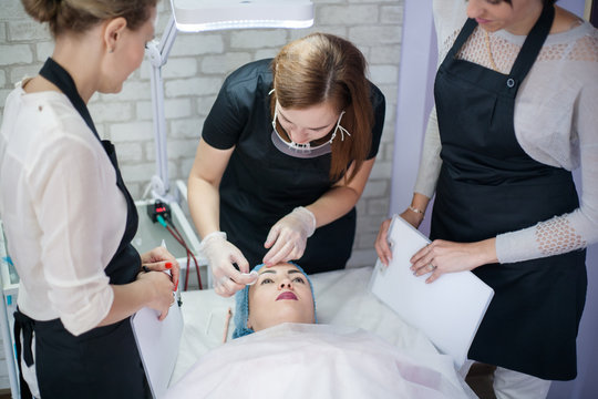 Professional skin care therapy. Female beauticians working with client in modern clinic.