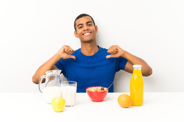 Young man having breakfast in a table proud and self-satisfied