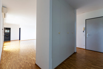 Large empty room with white walls and 70's parquet