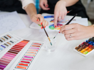 Makeup courses. Cropped shot of ladies studying colors, using lipstick palette, paint and brushes.