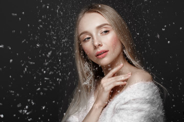 Beautiful blonde girl in a winter image with snow. Beauty face.
