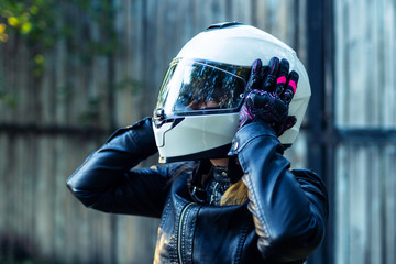 Woman puts on motorcycle helmet and fastens clasp