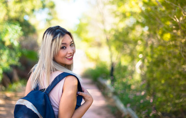 Student young girl with backpack in a park