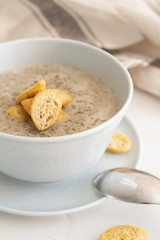 mushroom cream soup with breadcrumbs on a white plate