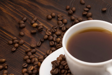 Cup of coffee surrounded by coffee beans.