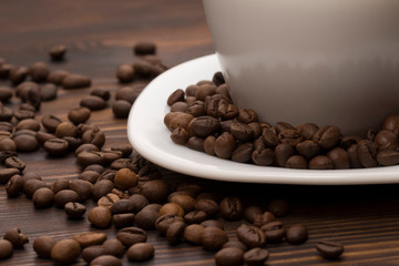 Cup of coffee surrounded by coffee beans.