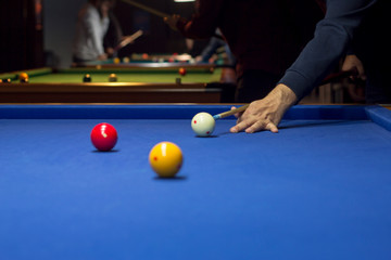 Fototapeta premium Unrecognizable man playing billiard taking aim