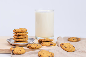 Cookies and fresh milk placed on a wooden plate on a white background, break snacks, chocolate chip cookies