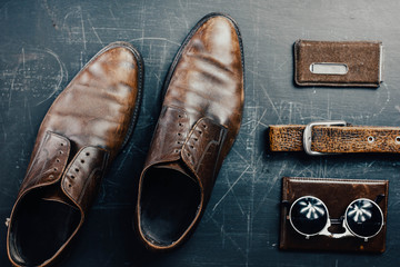 Leather accessories, brown shoes, passport cover, belt and sunglasses. Travel concept.