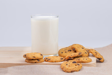 Cookies and fresh milk placed on a wooden plate on a white background, break snacks, chocolate chip cookies