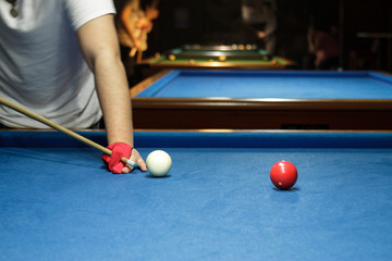 Unrecognizable man playing billiard taking aim