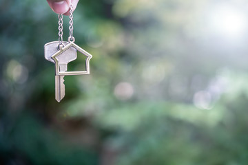 Home key with house keyring giving with blur house background