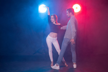 Social dance, kizomba, salsa and semba concept - young beautiful couple dancing bachata or salsa in the dark