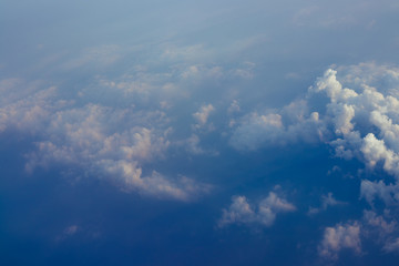 Aerial view sunset sky above clouds with dramatic light. View from airplane