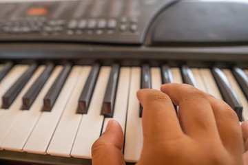Fototapeta premium Hands of the child are playing the keyboard or piano for music lessons, music concept