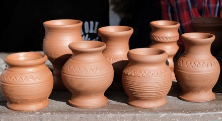 Fototapeta na wymiar Potter-shaped pots prepared for baking in an oven stand on the table.