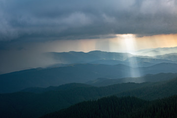 sun ray through thunderstorm clouds in the mountains