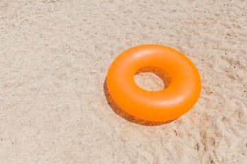 Obraz premium Yellow inflatable ring for swimming at sand beach on summer day