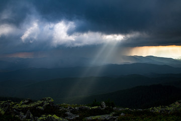 sun ray through thunderstorm clouds in the mountains