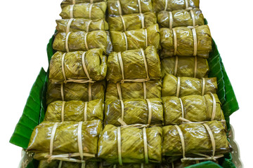 Boiled rice wrapped in banana leaves, white isolated.