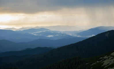 Fototapeta na wymiar sun ray through thunderstorm clouds in the mountains