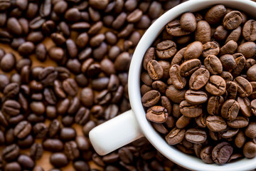 Coffee beans full in white coffee cup background 