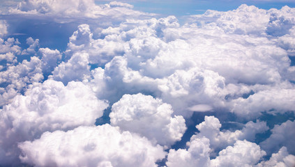 Naklejka na ściany i meble Fluffy white clouds on a blue sky background