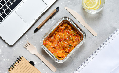 Food delivery. Lunch box with a diet lunch or breakfast or dinner on grey office table. takeaway lunch at the office. Top view . takeout healthy lunch. selective focus