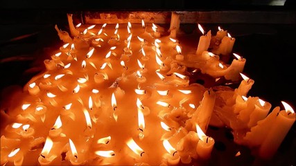 Many candles burning in the dark church