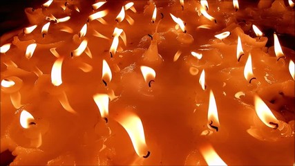 Many candles burning in the dark church