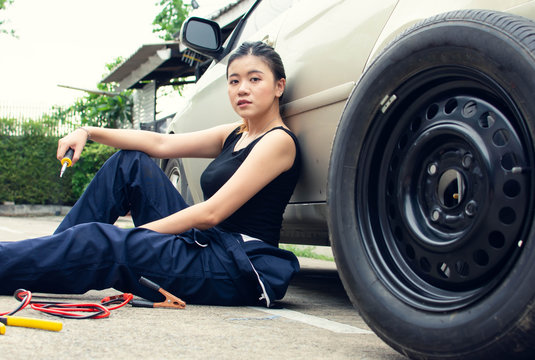 A woman is chaning tyre of car
