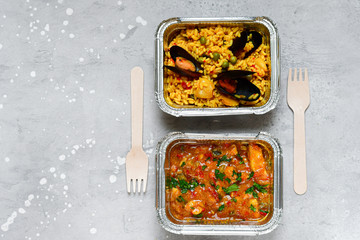 Food delivery.Different aluminium lunch box with healthy natural food pasta pesto, spelt, paella,...