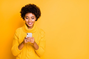 Copyspace photo of cheerful cute charming girlfriend browsing through her smartphone wearing pullover addicted to social media isolated with vibrant color background