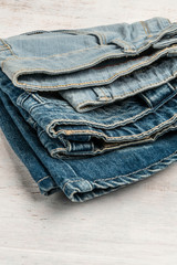 folded jeans on a wooden background with copy space