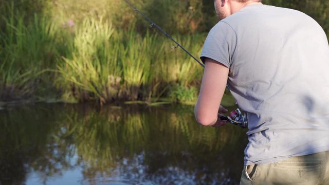 A man geek is fishing by the river and catching some computer parts. Water pollution concept. New technology idea concept.
