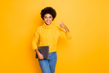 Portrait of her she nice attractive lovely smart clever cheerful confident wavy-haired girl carrying laptop showing thumbup cool good isolated over bright vivid shine vibrant yellow color background