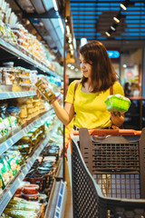 young pretty adult woman do shopping in grocery store