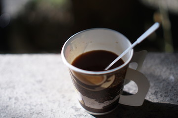 cup of coffee on wooden table in the garden